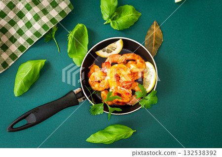 Juicy fried shrimp with lemon slices in the kitchen in a pan Juicy fried shrimp with lemon slices in the kitchen in a pan 132538392