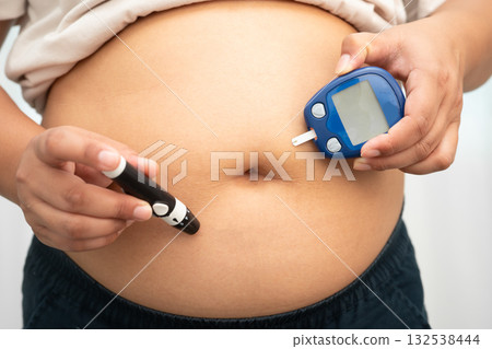 Asian woman injecting herself diabetes injecting insulin in stomach at home. 132538444