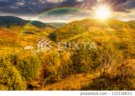 autumn landscape in mountains at sunset. beautiful view of countryside. colorful alps in the background. cloudy sky. picturesque rural scenery with village in the valley in evening light autumn landscape in mountains at sunset. beautiful view of countryside. colorful alps in the background. cloudy sky. picturesque rural scenery with village in the valley in evening light 132538653