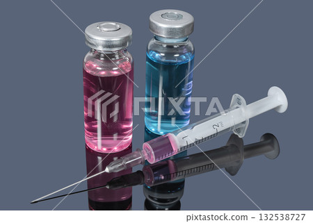 Medical vials with colored vaccines and syringe on dark background 132538727