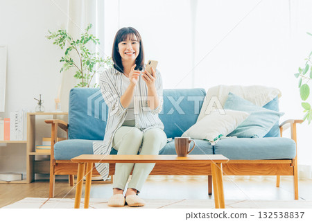 在客廳裡使用智能手機的年輕女子 132538837