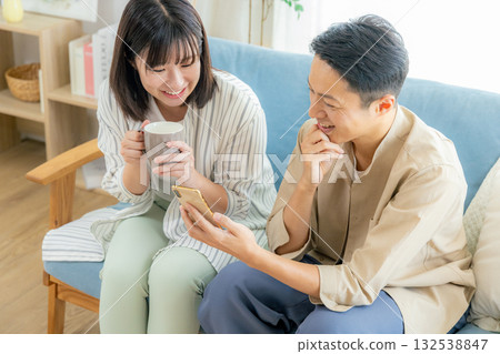 一對夫婦在客廳看智慧型手機 132538847