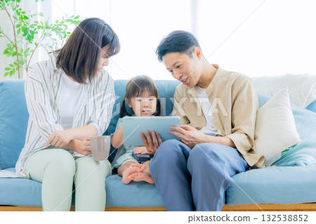 family looking at tablet in living room 132538852