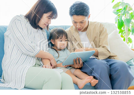 family looking at tablet in living room family looking at tablet in living room 132538855