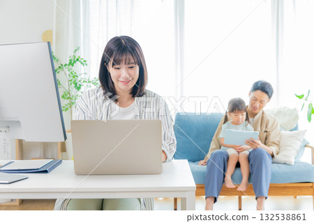 Parent and child using a personal computer in the living room Parent and child using a personal computer in the living room 132538861