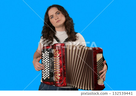 Young woman with a button accordion. Adult woman plays the button accordion Young woman with a button accordion. Adult woman plays the button accordion 132539441
