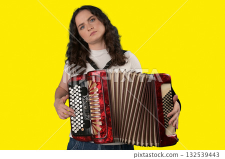 Young woman with a button accordion. Adult woman plays the button accordion Young woman with a button accordion. Adult woman plays the button accordion 132539443