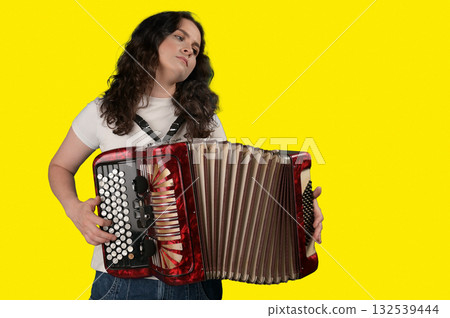 Young woman with a button accordion. Adult woman plays the button accordion 132539444