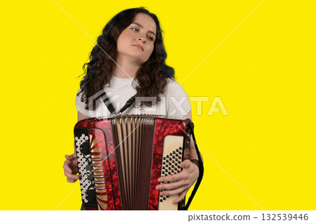 Young woman with a button accordion. Adult woman plays the button accordion 132539446