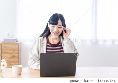 Young woman operating a personal computer at home Young woman operating a personal computer at home 132540124