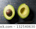 Fresh avocado halves on dark stone background 132540630