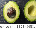 Fresh avocado halves on dark stone background 132540631