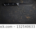 Black kitchen knife on dark stone background, top view 132540633