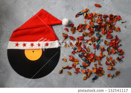 Merry Christmas design with vinyl record on the wooden background. With santa claus hat. Merry Christmas design with vinyl record on the wooden background. With santa claus hat. 132541117