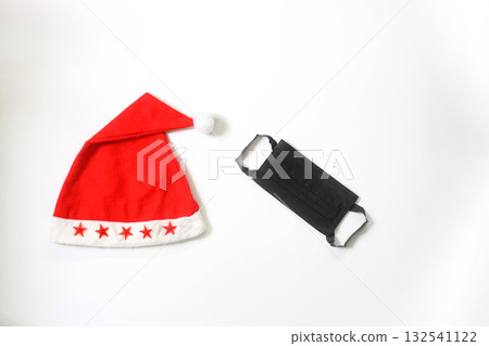 Funny christmas greeting card with santa hat and medical face mask. Flat lay with copy space 132541122