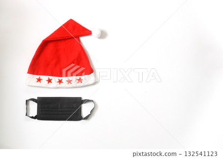 Funny christmas greeting card with santa hat and medical face mask. Flat lay with copy space Funny christmas greeting card with santa hat and medical face mask. Flat lay with copy space 132541123