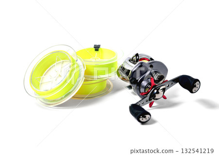 fishing reel and braided cord in coils of yellow color on white background close-up fishing reel and braided cord in coils of yellow color on white background close-up 132541219