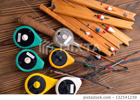 Many fishing rods for winter fishing on a brown natural wooden background 132541239