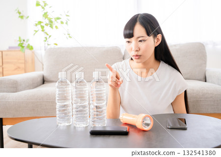 A young woman checking disaster prevention supplies A young woman checking disaster prevention supplies 132541380