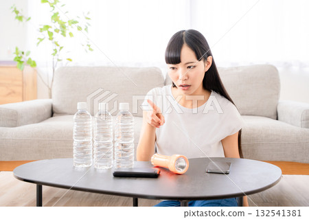 一名年輕女子正在檢查防災物資。 132541381