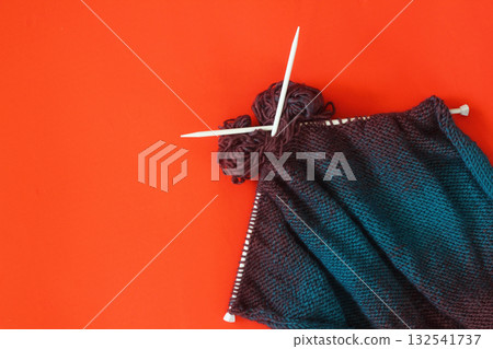 knitted sweater with white skewers on the red background. And gitf box knitted sweater with white skewers on the red background. And gitf box 132541737