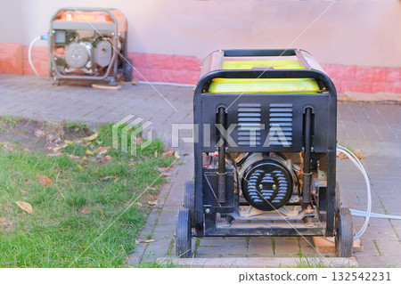 Energy independence. Business use mobile generator. Power supply generator placed on street sidewalk. Outdoor diesel power generator in autumn season. Energy independence. Business use mobile generator. Power supply generator placed on street sidewalk. Outdoor diesel power generator in autumn season. 132542231