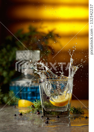 Slice of lemon fall in glass with cocktail, creating beautiful splashes. Slice of lemon fall in glass with cocktail, creating beautiful splashes. 132542237