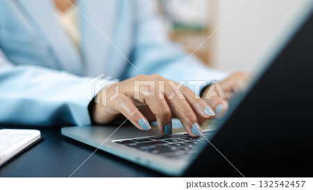 Businesswoman Typing on Laptop Computer in Office Workspace Businesswoman Typing on Laptop Computer in Office Workspace 132542457
