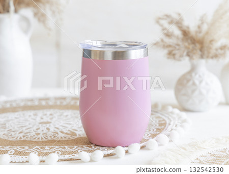 Pink stainless steel 12oz tumbler on boho placemat near pampas grass Closeup, mockup Pink stainless steel 12oz tumbler on boho placemat near pampas grass Closeup, mockup 132542530