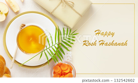 Rosh hashanah, Jewish New Year holiday card. Traditional symbols, apples, honey, carrots, hala and gift on a beige background with congratulations text Happy Rosh Hashanah 132542602