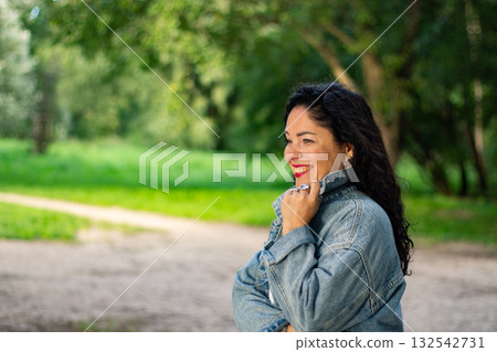 Woman enjoying peaceful moment in public park. Pensive woman. Candid moment. Feelings of tranquility mindfulness and connection with nature. Woman enjoying peaceful moment in public park. Pensive woman. Candid moment. Feelings of tranquility mindfulness and connection with nature. 132542731