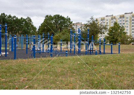 Open-air city sports ground with outdoor exercise equipment. Sports complex in a residential area. Open-air city sports ground with outdoor exercise equipment. Sports complex in a residential area. 132542750