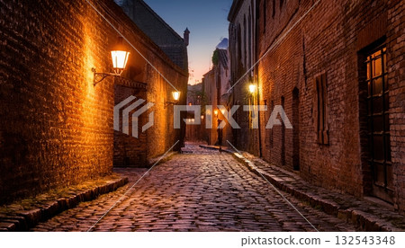 A serene cobblestone alley at night with warm lantern light illuminating ancient brick walls 132543348
