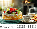 Morning Treat: Beautifully Decorated Orange Cake and Two Cups of Coffee with Visible Steam 132543538
