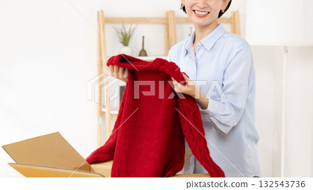 Woman holding winter clothes Woman holding winter clothes 132543736