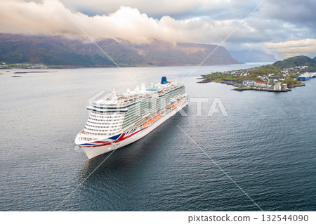 Grand cruise liner underway in scenic waters in Alesund town. Grand cruise liner underway in scenic waters in Alesund town. 132544090