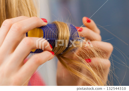 Woman curling her hair using rollers Woman curling her hair using rollers 132544310
