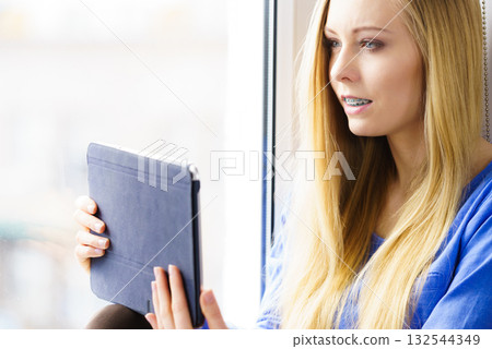 Student girl with tablet sitting on windowsill 132544349