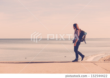 Man hiker with backpack tramping by seaside 132544422