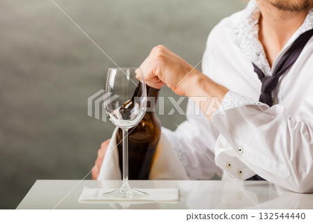 Man waiter pouring wine into glass. Man waiter pouring wine into glass. 132544440