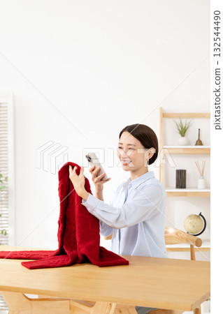 Woman taking a photo of clothes Woman taking a photo of clothes 132544490