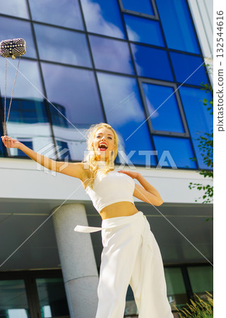 Cheerful fashionable woman in city Cheerful fashionable woman in city 132544616