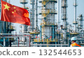 Industrial oil refinery with towering structures and pipeline under clear sky, featuring Chinese flag and worker in safety gear. Concept of energy production, industry, and China national development 132544653