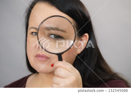 Adult woman with magnifying glass 132545086
