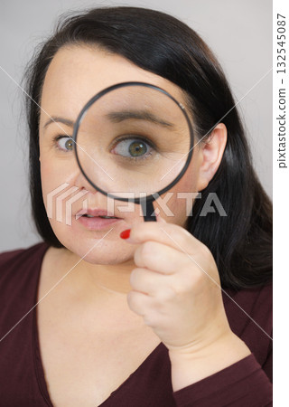 Adult woman with magnifying glass 132545087