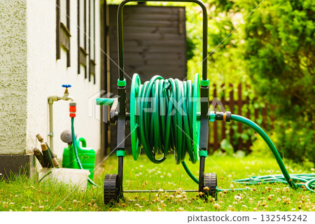 Garden hose for watering plants in garden Garden hose for watering plants in garden 132545242