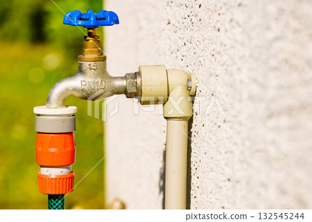 Garden tap with hosepipe attached. Garden tap with hosepipe attached. 132545244