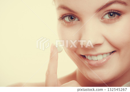 woman applying cream on her skin face. 132545267