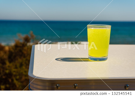 Citrus drink in glass on sea shore 132545541