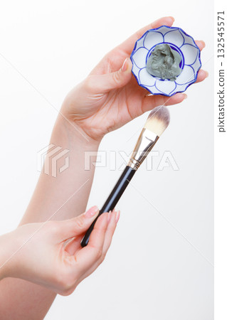 Woman mixing face mask in little porcelain bowl Woman mixing face mask in little porcelain bowl 132545571